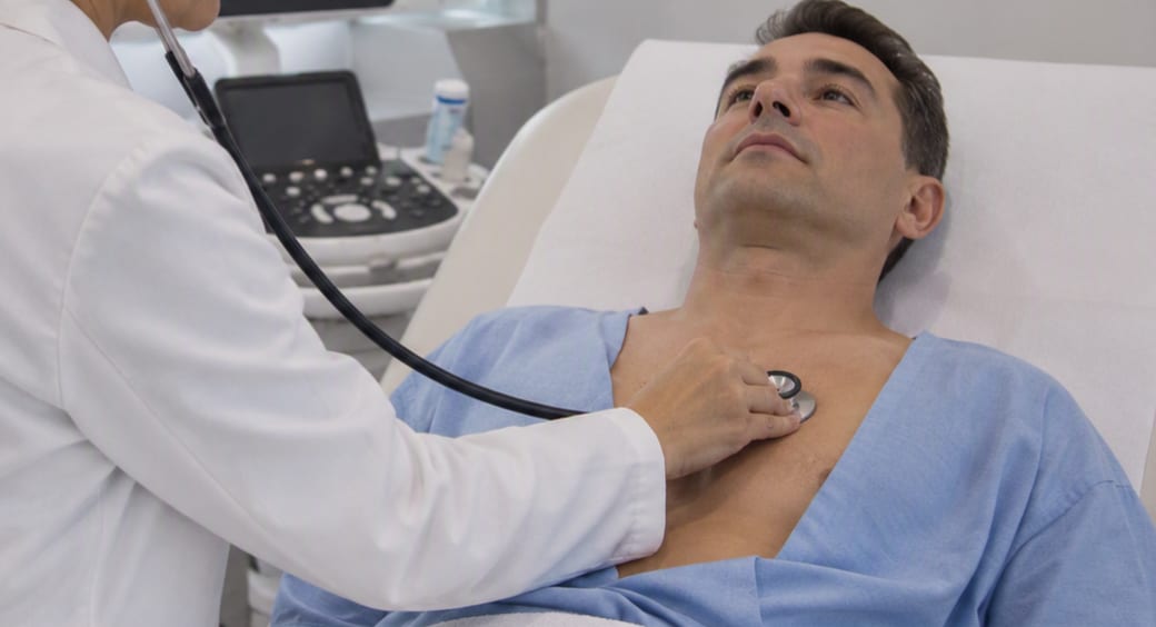A doctor listening to a patient’s heart with a stethoscope